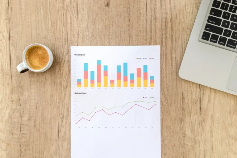 Printed SEO crawl report with charts next to a laptop and coffee