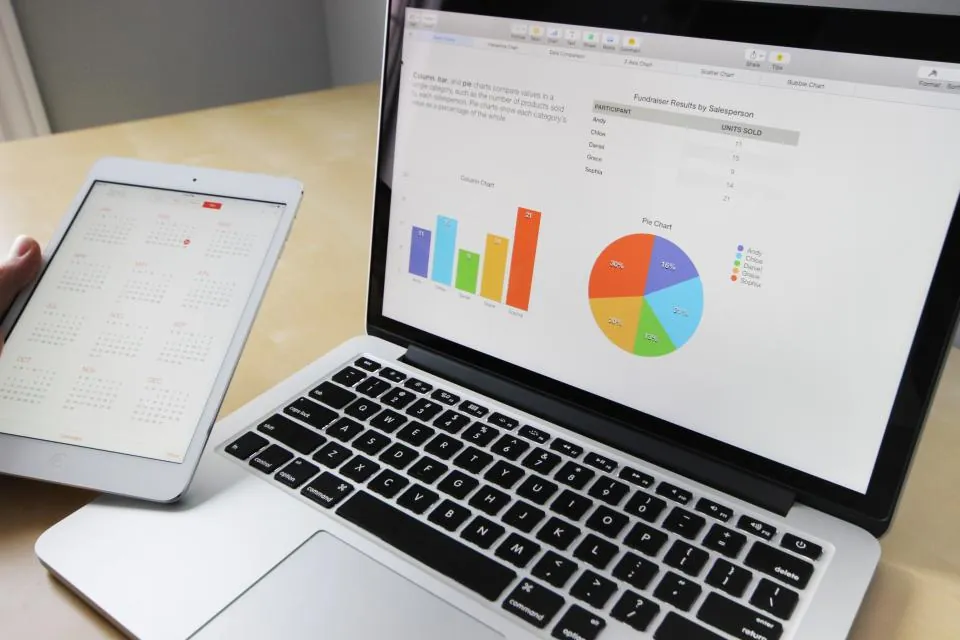 Laptop showing charts and a tablet calendar, used to plan and track a website SEO audit